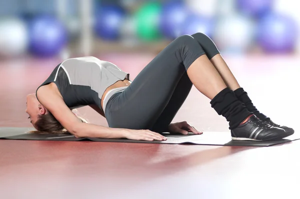 Kvinna gör stretching fitness motion på sport gym. Yoga — Stockfoto