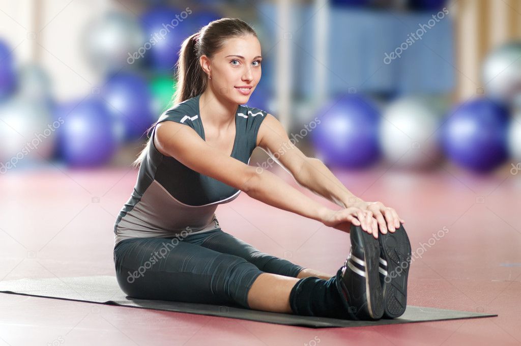 Woman doing stretching fitness exercise at sport gym. Yoga