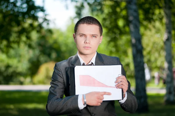 Um homem de negócios mostra o gráfico no Park. Estudante — Fotografia de Stock