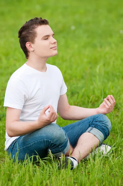 A young man doing yoga at park — Stock Photo, Image