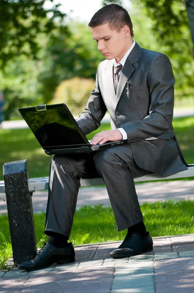 El hombre de negocios trabaja en un cuaderno en Park. Estudiante — Foto de Stock