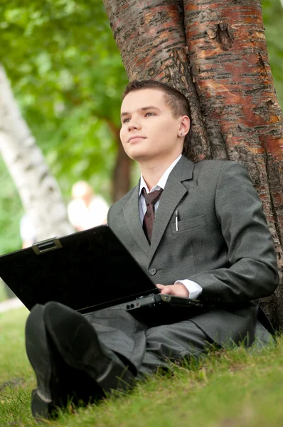 Бізнесмен працює на ноутбуці в парку. Студентська — стокове фото