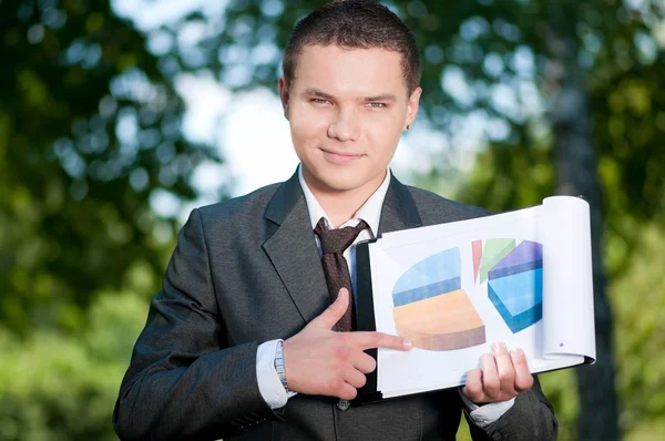 Un uomo d'affari mostra un grafico al parco. Studente — Foto Stock