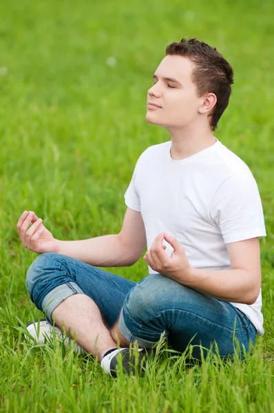 Een jonge man doen yoga bij park — Stockfoto