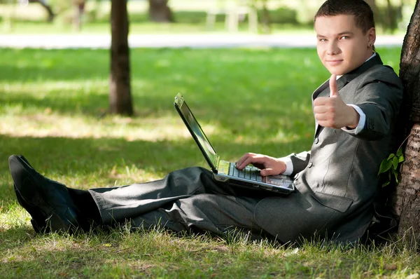 El hombre de negocios trabaja en un cuaderno en Park. Estudiante — Foto de Stock