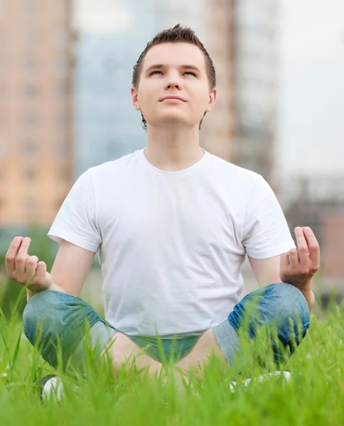 Park yoga yaparken genç bir adam — Stok fotoğraf