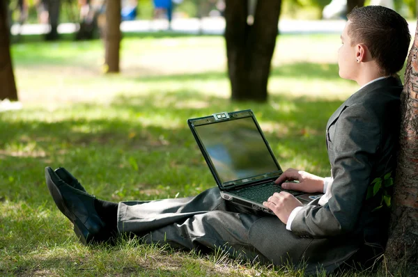 ビジネスの男性は公園でノートブックに取り組んでいます。学生 — ストック写真