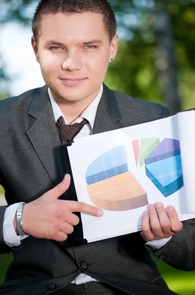 Um homem de negócios mostra o gráfico no Park. Estudante — Fotografia de Stock