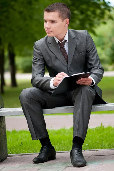 Geschäftsmann, der im Park mit Papieren arbeitet. Schüler — Stockfoto