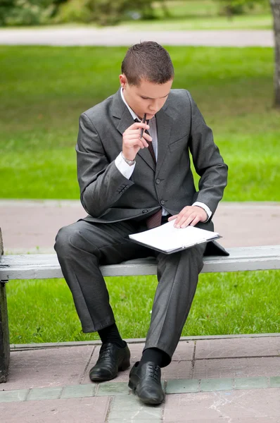 Homem de negócios a trabalhar com documentos no Park. Estudante — Fotografia de Stock