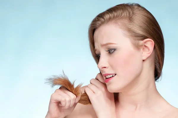 Ritratto ravvicinato di giovane donna scontenta con le estremità dei capelli — Foto Stock