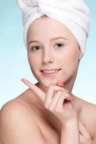 Beautiful woman applying moisturizer cream on face — Stock Photo, Image