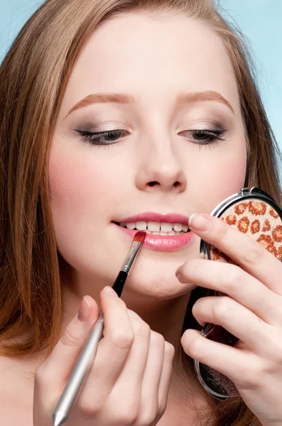Beautiful young adult woman applying cosmetic lipstick brush — Stock Photo, Image