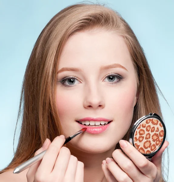 Hermosa mujer joven adulta aplicando cepillo de lápiz labial cosmético — Foto de Stock