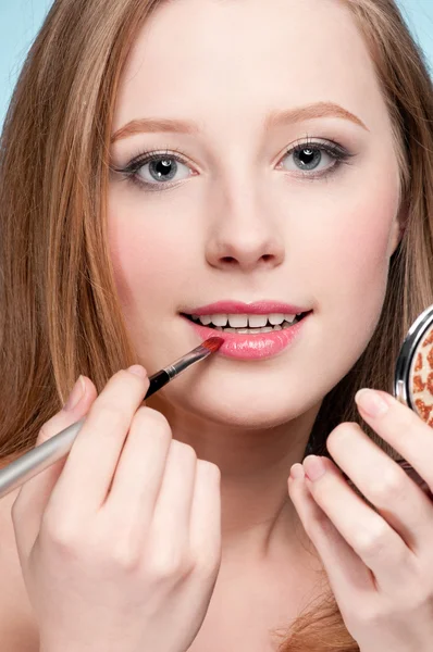 Bella giovane donna adulta che applica pennello rossetto cosmetico — Foto Stock