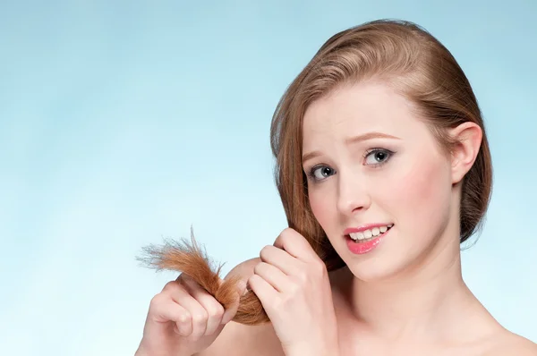 Close up portrait of young displeasure woman with hair ends — Stock Photo, Image