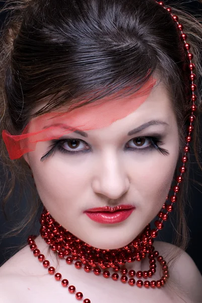 Close up portrait of girl with red lips and beads on black — Stock Photo, Image