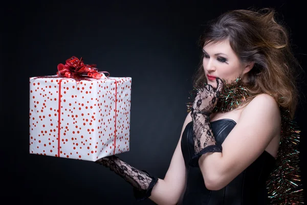 stock image Closeup portrait of girl with red lips, tinsel and present on bl