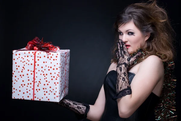 Портрет крупным планом девушки с красными губами, мишурой и подарком на bl — стоковое фото