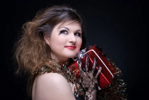 Closeup portrait of girl with red lips, tinsel and present on bl — Stock Photo, Image