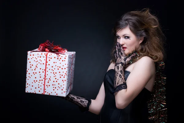 Портрет крупным планом девушки с красными губами, мишурой и подарком на bl — стоковое фото