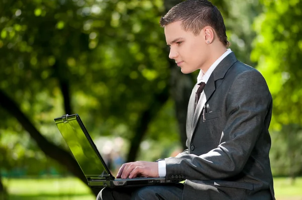 Business man work on notebook at park. Student Royalty Free Stock Photos