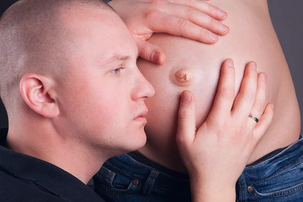 Man met de buik van een zwangere vrouw — Stockfoto