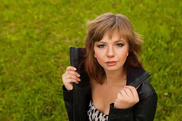 Çim zemin üzerine kahverengi saçlı genç kız — Stok fotoğraf