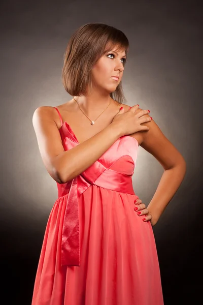 Portret młodej kobiety w różowej sukience — Zdjęcie stockowe