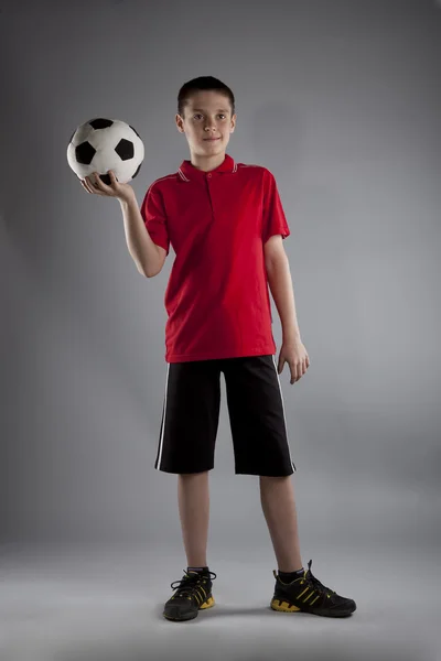 Menino com bola de futebol posando em estúdio — Fotografia de Stock