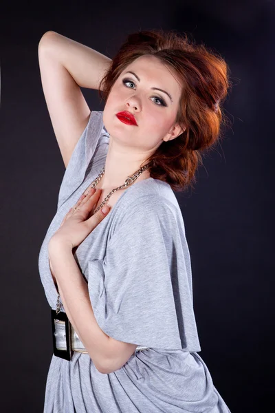 Portrait of a red-haired girl in a gray dress — Stock Photo, Image