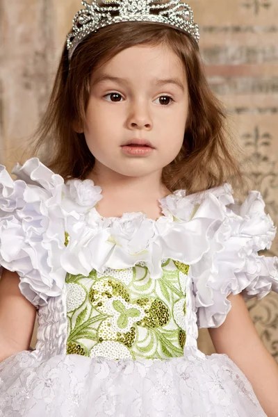 Kleines Mädchen im weißen Kleid mit einem Diadem auf dem Kopf — Stockfoto