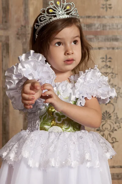 Little girl in white dress with a tiara on her head — Stock Photo, Image
