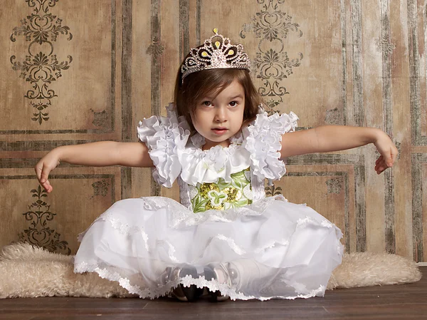Klein meisje in witte jurk met een tiara op haar hoofd — Stockfoto