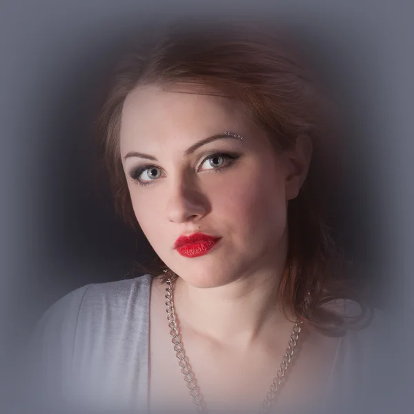 Retrato de uma menina com lábios vermelhos em um vestido cinza — Fotografia de Stock