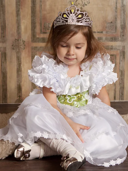 Маленька дівчинка в білій сукні з тіарою на голові — стокове фото