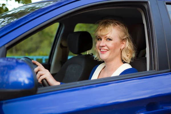 Blonde woman sitting behind the wheel of a car — Stock Photo, Image