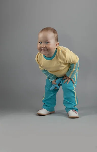 En liten flicka i gul blå kostym poserar i studio — Stockfoto