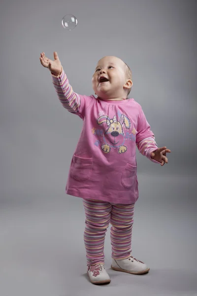 Una bambina in abito rosa in posa in studio con un sapone bub — Foto Stock