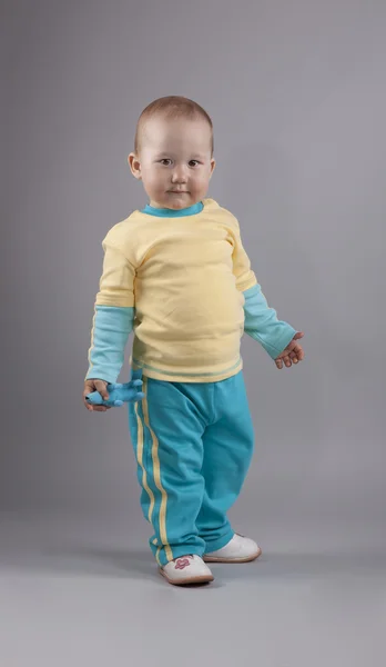 Ein kleines Mädchen im gelb-blauen Anzug posiert im Studio — Stockfoto