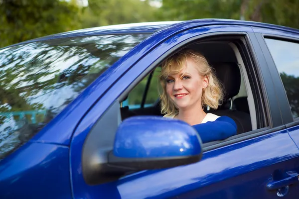 Blond kobieta siedziała za kierownicą samochodu Obrazek Stockowy