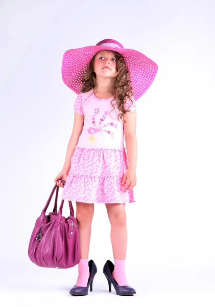 Malá holčička v krásné růžové šaty s kloboukem a pytel — Stock fotografie