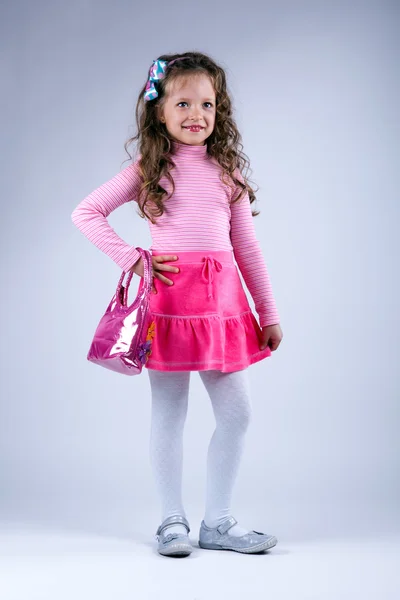 Klein meisje in een mooie roze jurk — Stockfoto