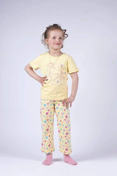 Schattig klein meisje in gele pyjama 's — Stockfoto