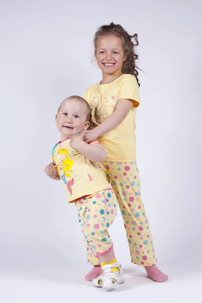 Två söta flickor i rosa pyjamas — Stockfoto