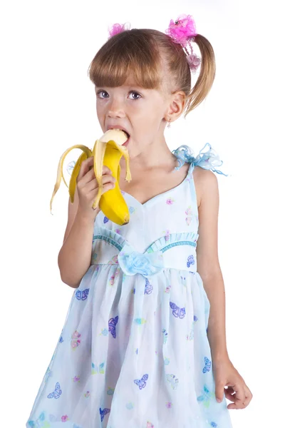 Όμορφο κορίτσι σε ένα μπλε φόρεμα με μια μπανάνα στα χέρια της — Φωτογραφία Αρχείου