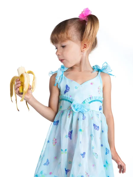 Hübsches Mädchen in einem blauen Kleid mit einer Banane in den Händen — Stockfoto