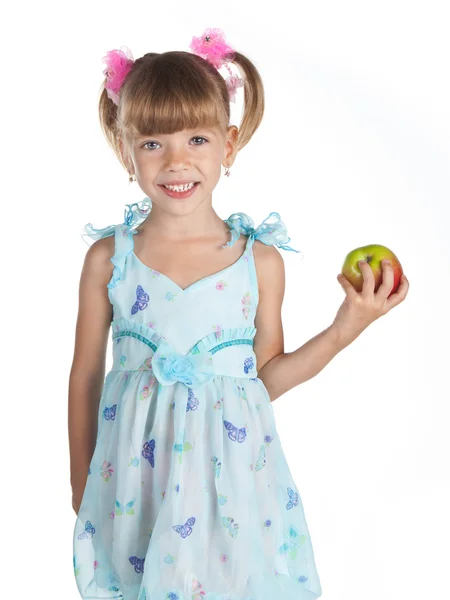Söt flicka i en blå klänning med ett äpple i handen — Stockfoto