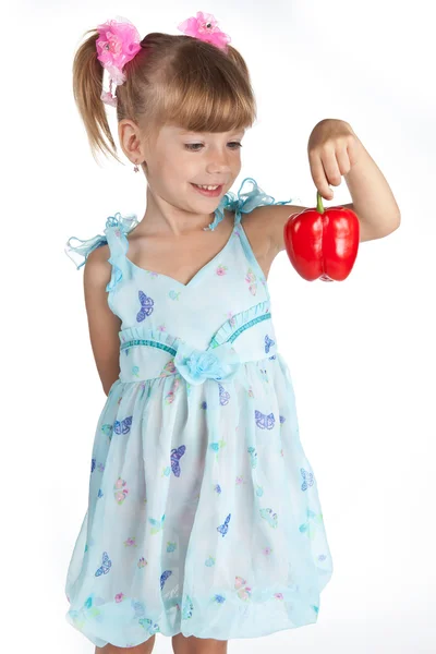 Ένα γλυκό κοριτσάκι με μια κόκκινη πιπεριά στο χέρι — Φωτογραφία Αρχείου