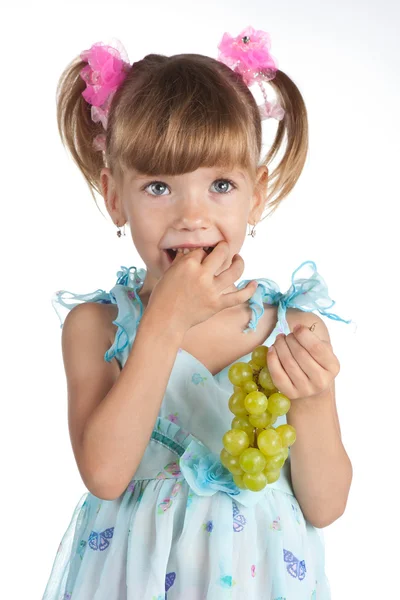 Mooi klein meisje met groene druiven in haar hand — Stockfoto